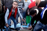 Libyan protesters stomp on a poster of leader Moamar Gaddafi