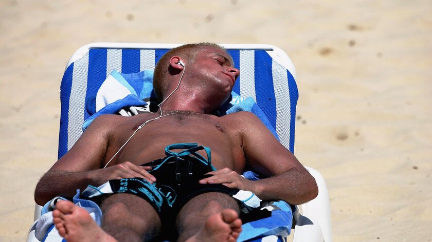 A male sunbather soaks up the summer sun on Bondi Beach November 3, 2005 in Sydney