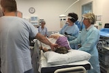 Nurse endoscopist Lea Wiggins (centre with dark hair) performs a colonoscopy on a patient