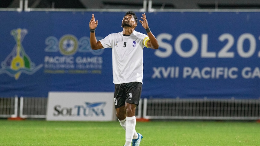 Roy Krishna points to the sky on the field.