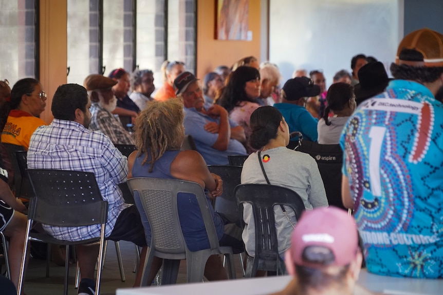 backs turned at a community meeting