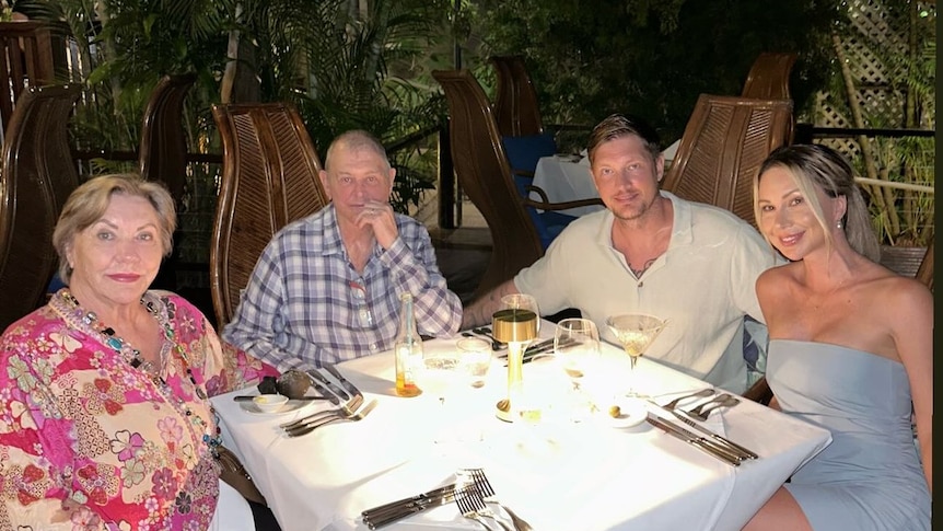 Singer John Farnham sitting at a restaurant with his wife, son, and son's wife melissa at the table with him