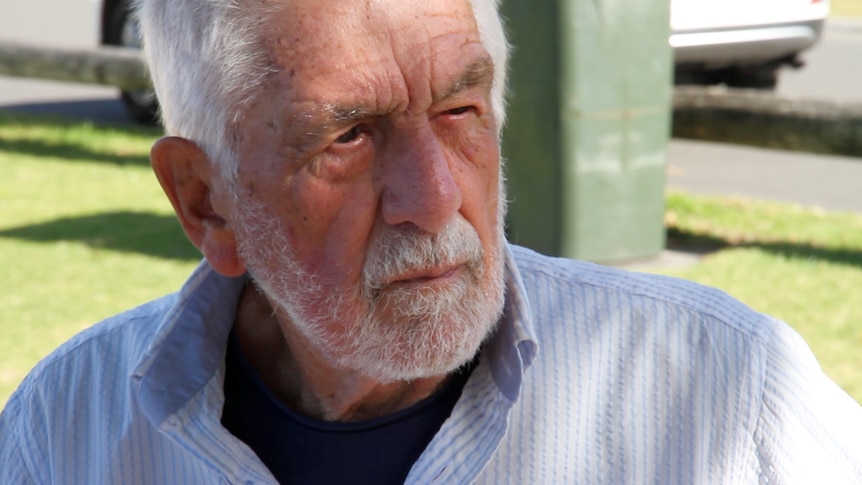 A close up image of an older man with white beard and hair.