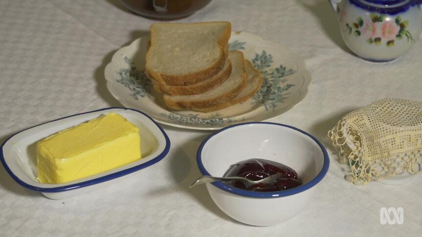 Sliced bread, butter and jam on table