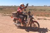 A man, riding a postie bike, on a dirt road in WA's Pilbara