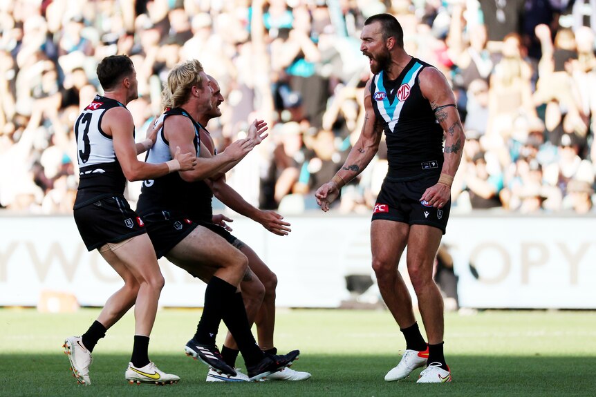 Charlie Dixon screams in delight as teammates approach him to celebrate