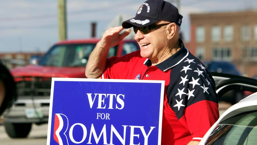 A supporter of Mitt Romney salutes as he campaigns on presidential primary day 2012 in Manchester, New Hampshire.