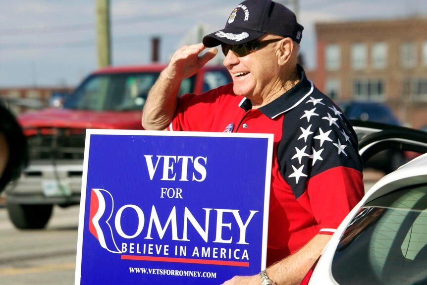 A supporter of Mitt Romney salutes as he campaigns on presidential primary day 2012 in Manchester, New Hampshire.