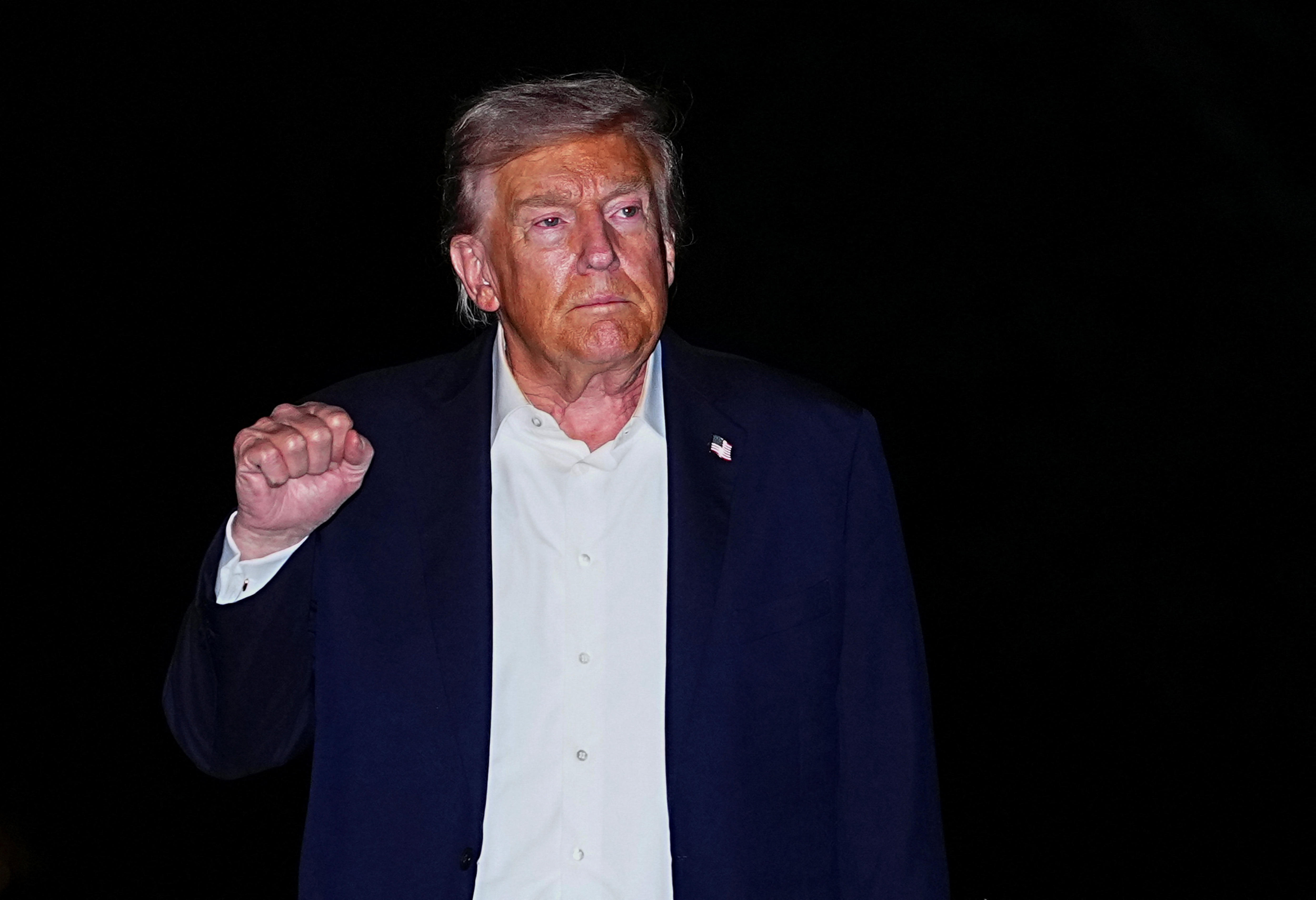 Donald Trump with a tired face gesturing with a closed fist