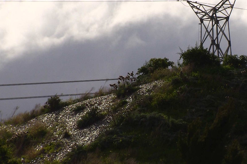 Glass can be seen on a mountain with a radio tower on top.