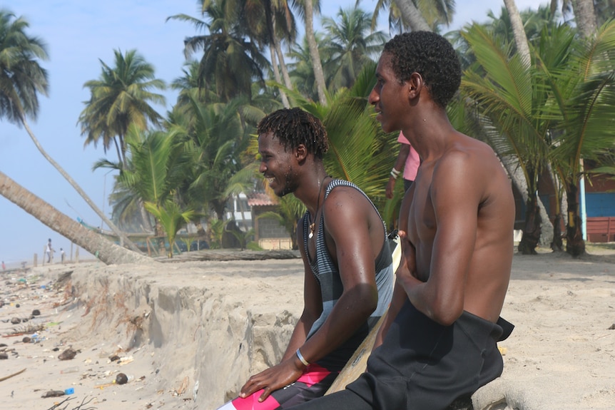 Two surfers gaze at the water