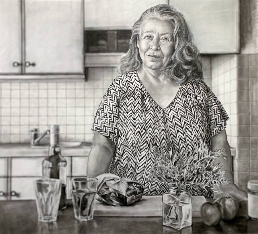 woman standing behind kitchen counter staring at the viewer