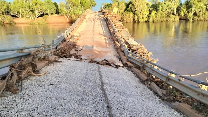 A bridge that has been warped and cracked by floodwaters.