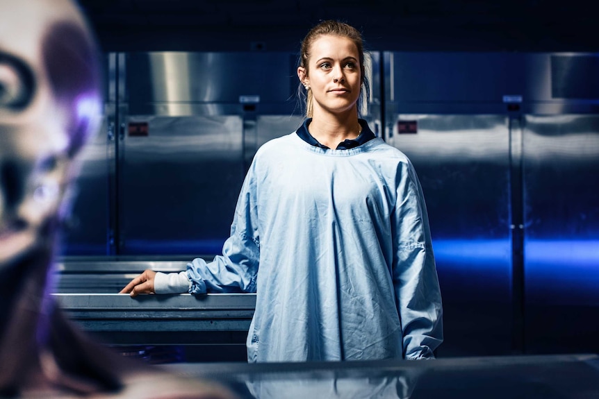 Katie Gaskin rests her hand on a lab table with a skeleton head in the foreground.