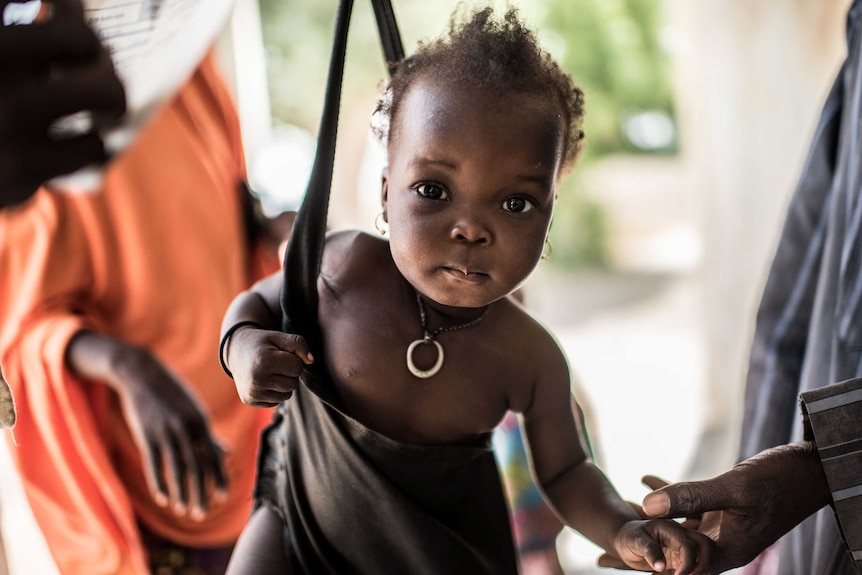 Halima, 2, is weighed during a visit to the outpatient therapeutic nutrition site at Kimeri, Maiduguri