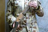 Lieutenant Colonel Darren Huxley in uniform holding the Martini-Henry 1880 rifle