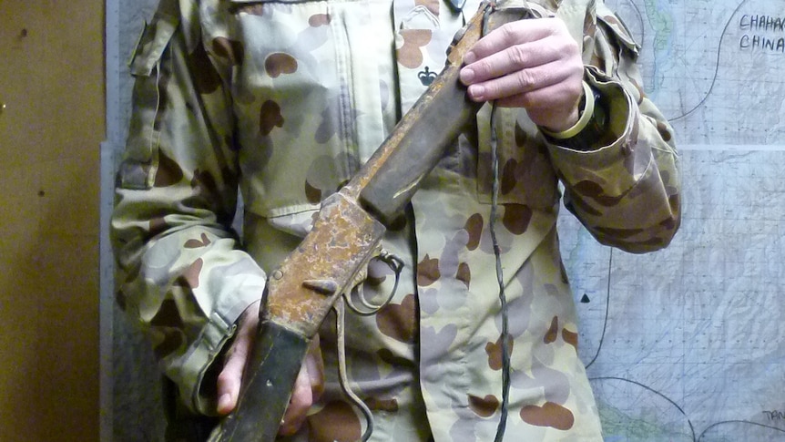 Lieutenant Colonel Darren Huxley in uniform holding the Martini-Henry 1880 rifle