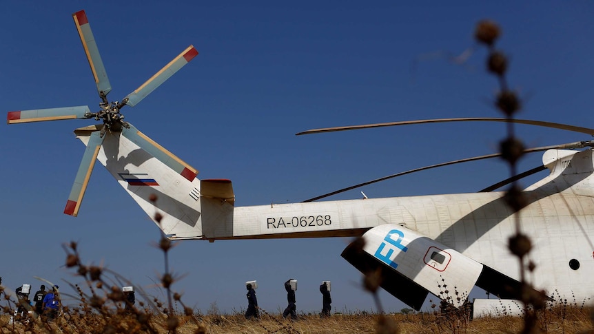 Men unload boxes of nutritional supplements from an helicopter in South Sudan.