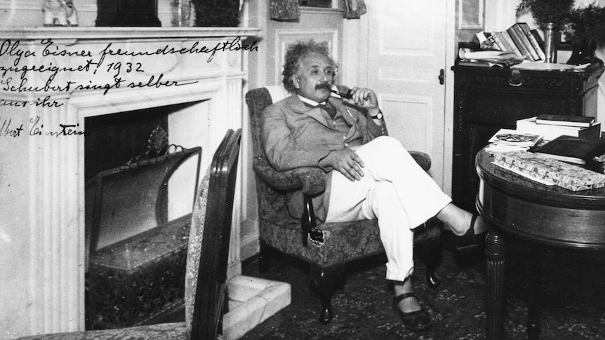 Portrait of physicist Albert Einstein sitting in an armchair and smoking a pipe, circa 1932.