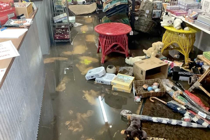Smalls store damaged by floods - the floor is wet and the broken stock has fallen to the ground.,