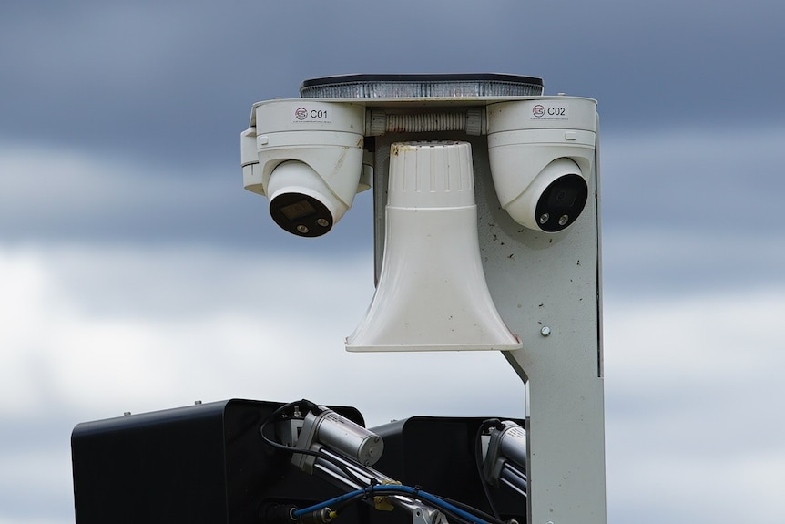Two security looking cameras as part of a bigger structure.