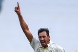 Australia bowler Mitchell Starc runs and shouts with a finger in the air after dismissing England's Zak Crawley (foreground).