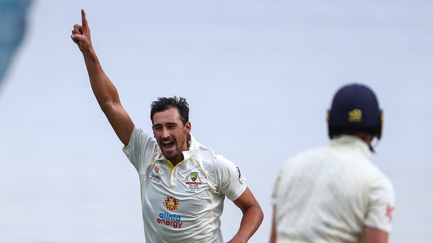 Australia bowler Mitchell Starc runs and shouts with a finger in the air after dismissing England's Zak Crawley (foreground).