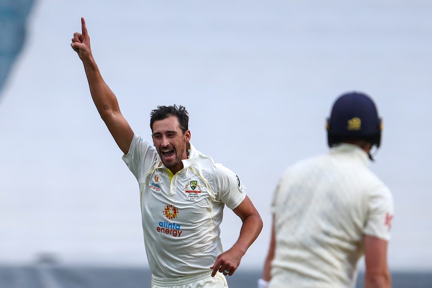 Australian bowler Mitchell Starc runs and yells with one finger in the air after brushing aside Englishman Zak Crawley (foreground).