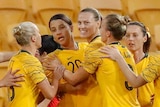 Sam Kerr is surrounded by teammates as she celebrates a goal for the Matildas.