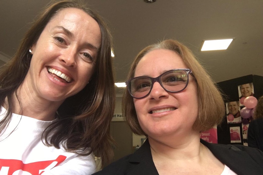 Two smiling women pose for a selfie.