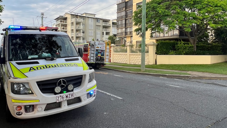 An ambulance in front of an apartment building. 