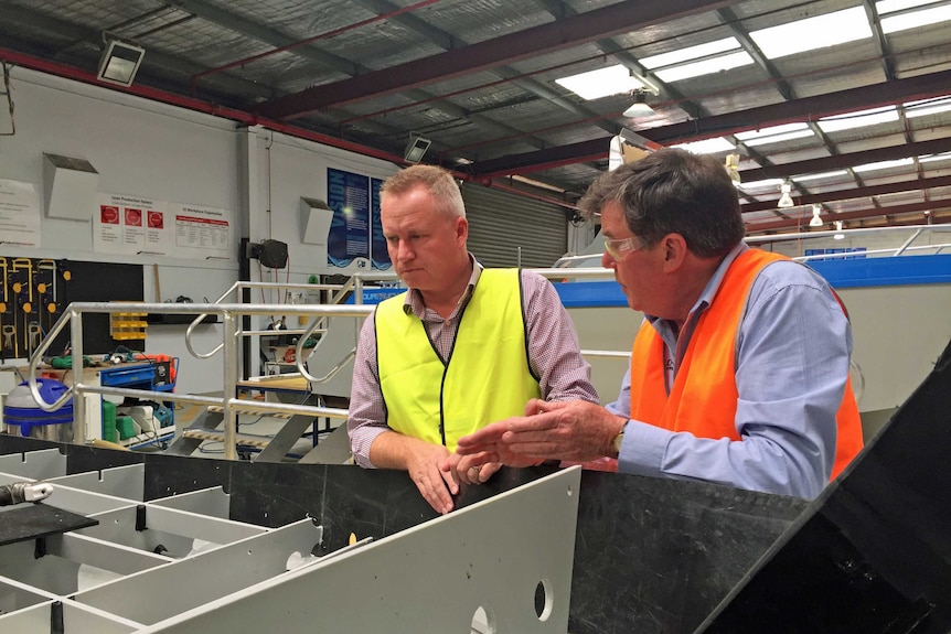 Jeremy Rockliff looks at a boat built by Rob Miley from Tasmanian company AquaTruck
