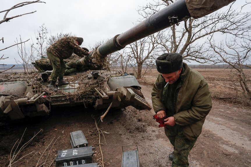 Pro-Russian separatists are seen next to an abandoned tank