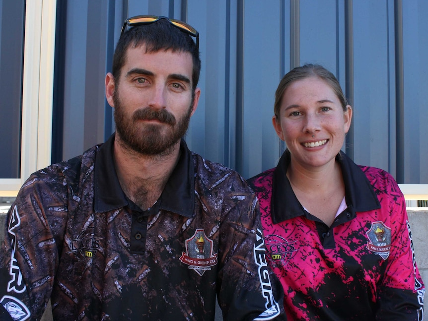 bearded man sitting with woman both wearing highly decorated shirts