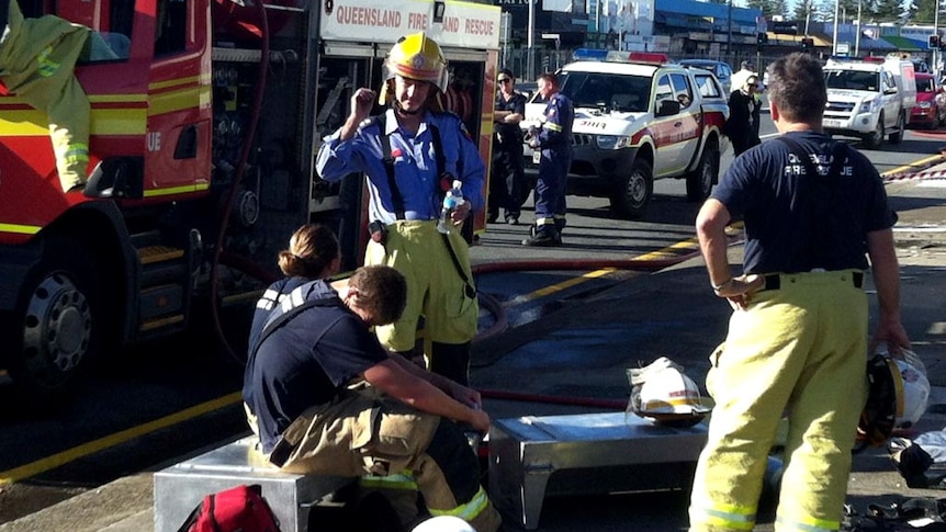 Firefighters rest after battling a fire in a disused building at Mermaid Beach.