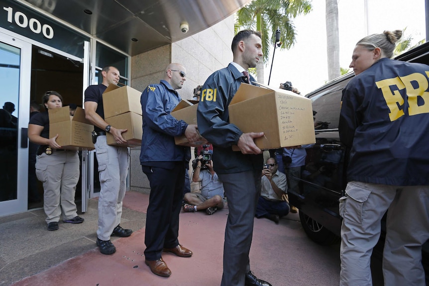 FBI agents carry boxes from the headquarters of CONCACAF (an American governing football body).