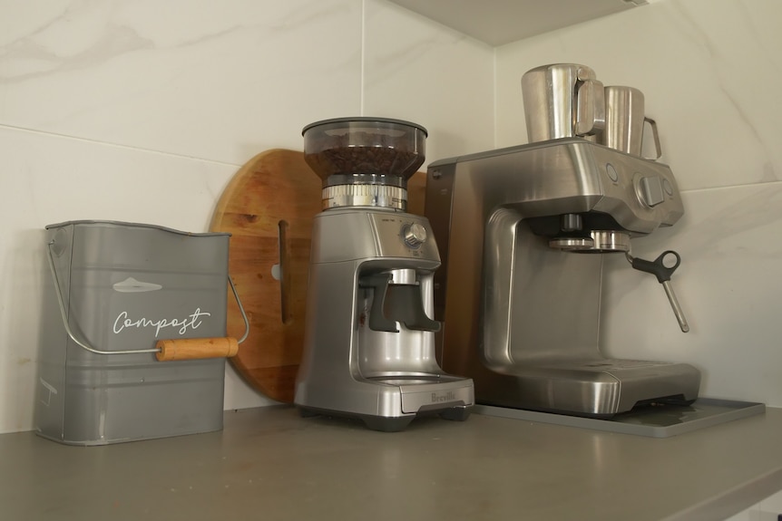 Coffeee machine and compost bin on a kitchen bench