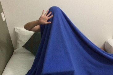 Allyson Horn recording her voice over under a bright blue blanket.