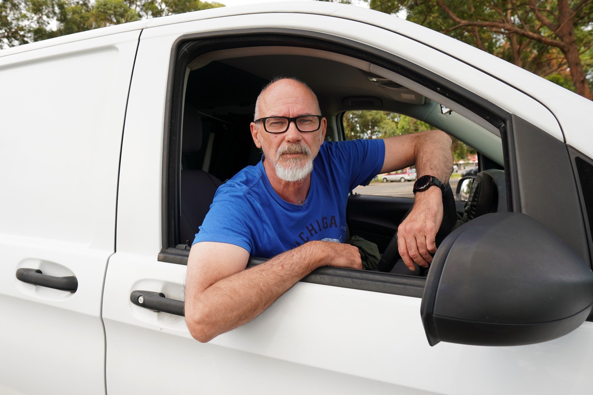 Man in car driver's seat of van.