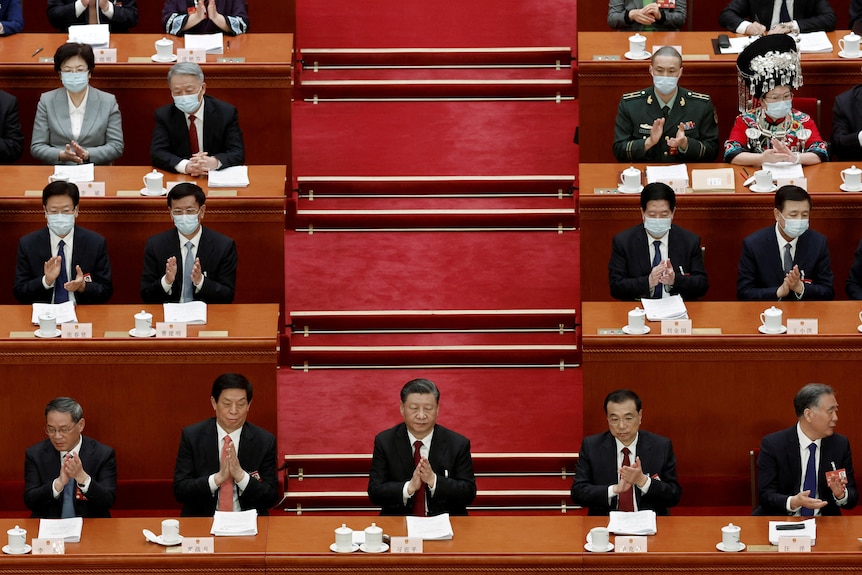 Xi Jinping applauds at the opening session of the National People's Congress.