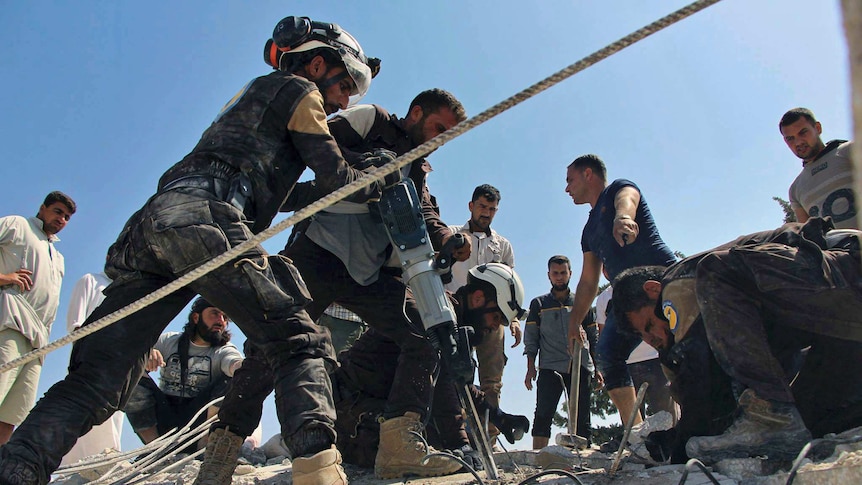 Civil Defence workers using a power drill to search through the rubble after airstrikes hit in the northern province of Idib.