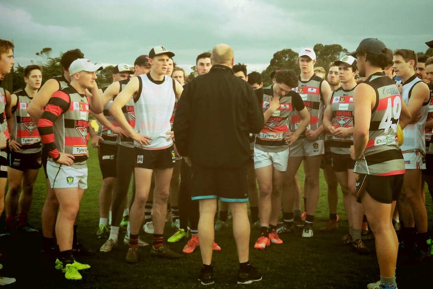 Lauderdale FC players listen to their coach at training in the lead up to the TSL Grand Final.