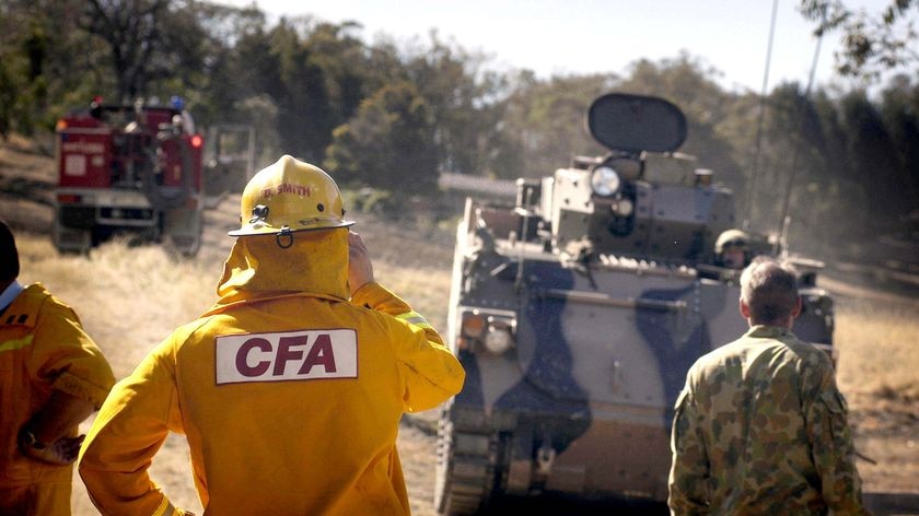 An Australian Army soldier and CFA firefighter map out the bushfire containment line
