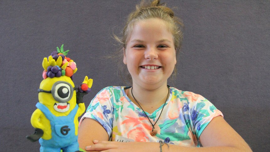 Young artist Lulu with her fruit minion sculpture