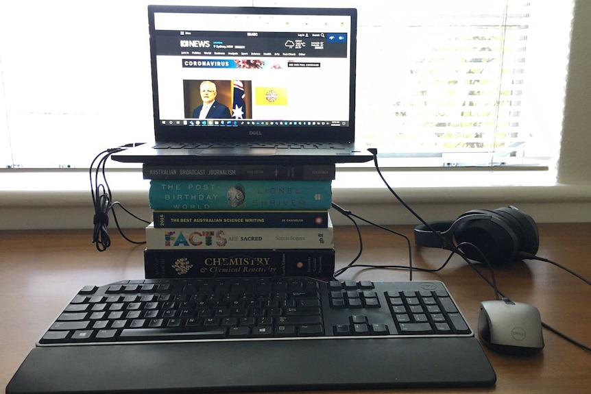 Laptop sitting on a pile of books