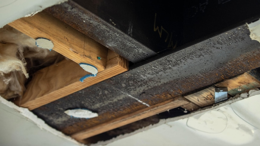 Rusted beams in a ceiling cavity.