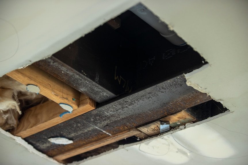 Rusted beams in a ceiling cavity.