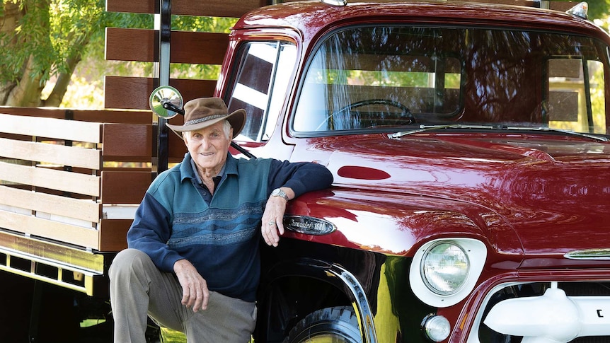 Norman Simon leaning against a restored Chev truck.