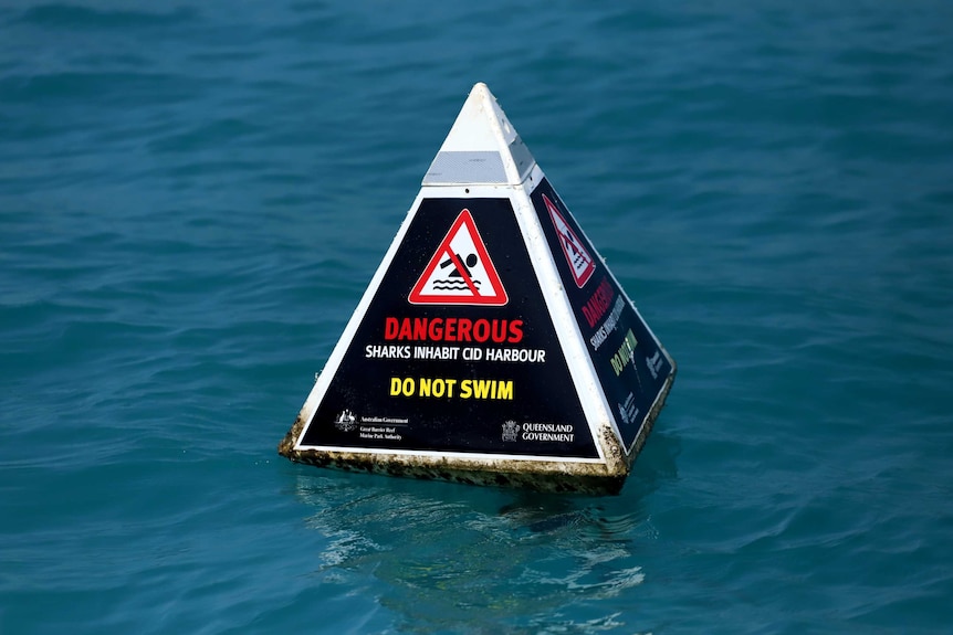 A buoy in the ocean says dangerous: do not swim