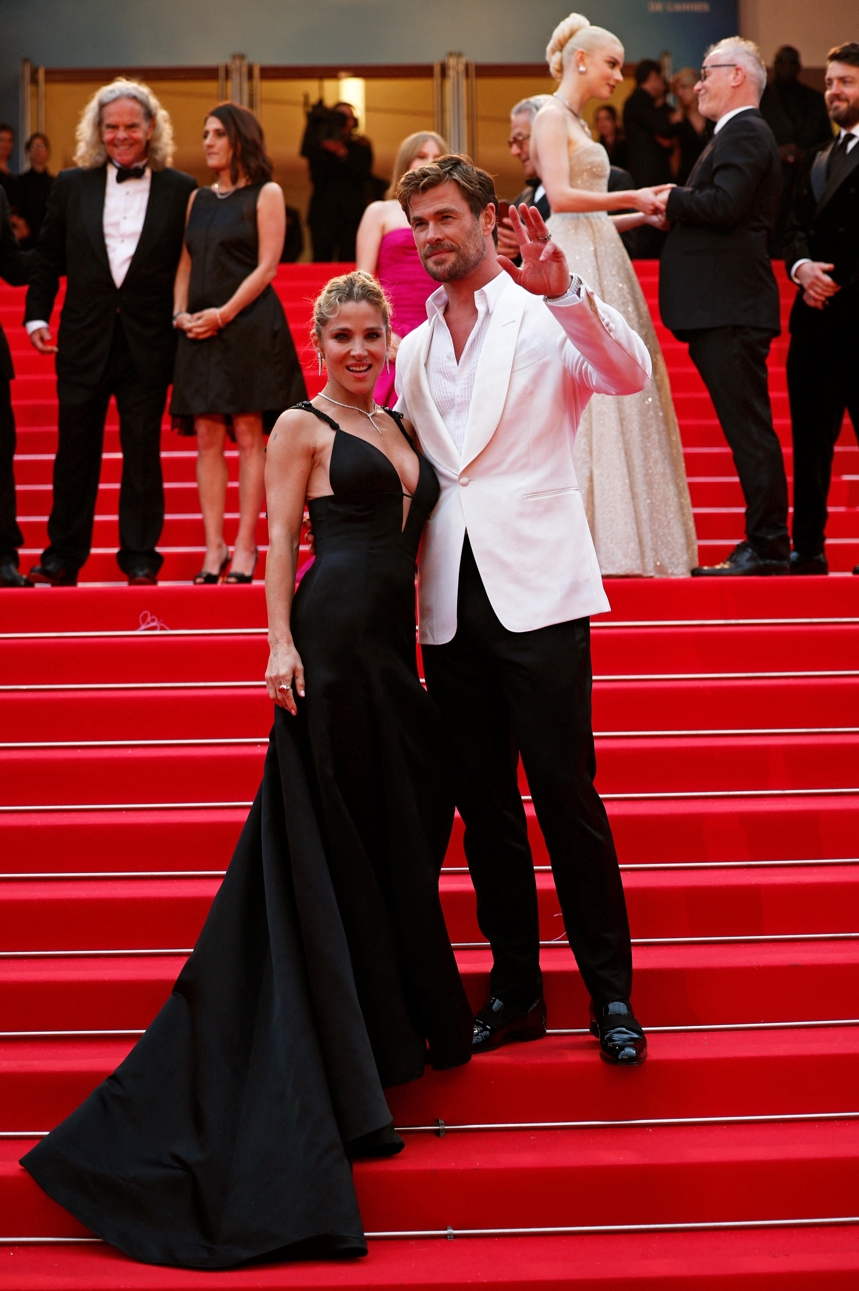 Chris Hemsworth in a white suit jacket and black trousers and Elsa Pataky in a long black gown